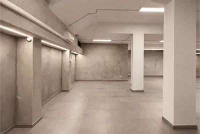 Open space con pareti in cemento e colonne – Spazio Chiave Milano