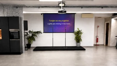 Palco con schermo e microfoni per serata karaoke – Spazio Chiave Milano